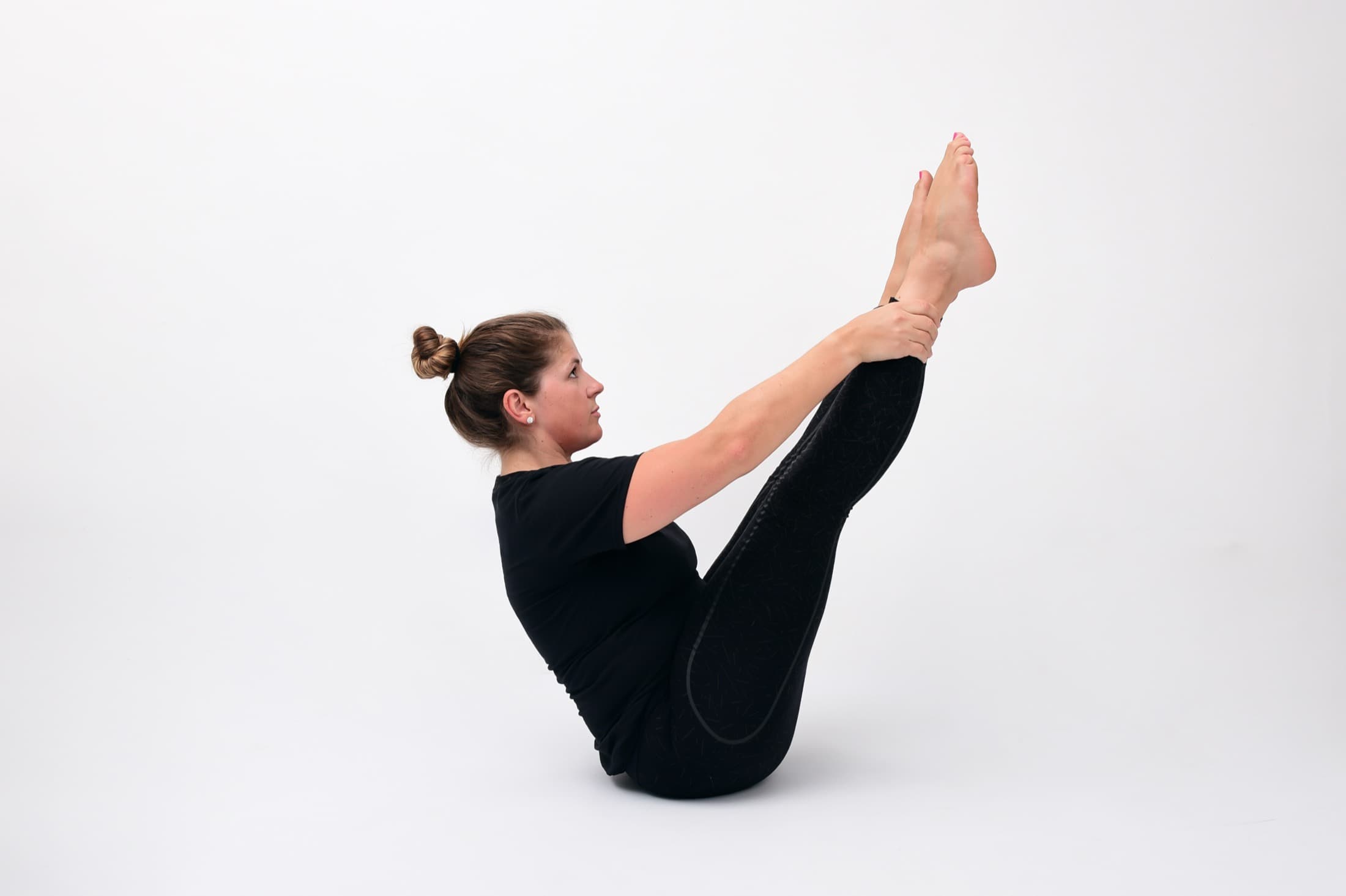 A single person working through a Pilates exercise on her own mat